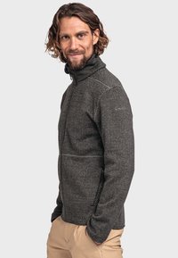 Schwarze Fleecejacke mit einem strukturierten Muster, durchgehendem Reißverschluss, hohem Kragen und zwei seitlichen Taschen. Entwickelt für Komfort und Wärme.