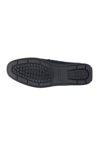 La suola in gomma presenta una superficie nera texture con motivi circolari antiscivolo. I bordi rinforzati e il marchio centrale migliorano la durabilità.