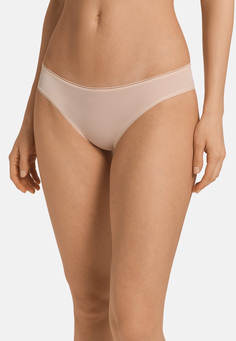 Perizoma bikini nudo senza cuciture con finitura liscia, caratterizzato da un taglio a vita bassa e un design minimalista, adatto per l'uso quotidiano.