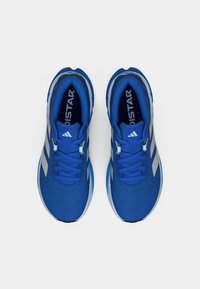 Sinised spordijalatsid tekstureeritud võrkmaterjalist pealsega, peegeldavate hõbedaste detailidega ja pehmendusega tald. Sisaldab narmastega paelu ja logo keelel.