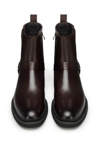 Bottes basses en cuir marron avec une finition lisse, bouts arrondis, fermetures éclair latérales et petites boucles en tissu à l'arrière pour un enfilage facile.