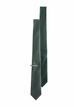 Two green ties: one with a geometric pattern, the other with circular motifs. Both have a smooth texture and a metal tie bar.