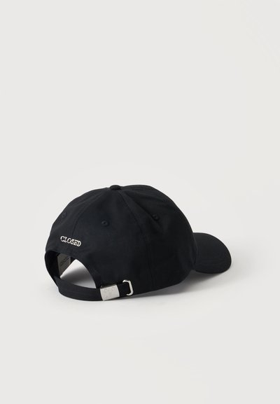 Casquette de baseball noire réglable avec boucle métallique et le mot "CLOSED" brodé au-dessus de l'ouverture à l'arrière sur un fond blanc uni.