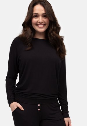 Zwart langemouwen top gemaakt van zachte stof, met een relaxed fit en ronde halslijn. Gecombineerd met zwarte broek met roze knoopdetails.