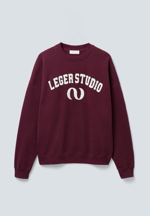 Burgunderfarget genser med rund hals og hvit "LEGERSTUDIO" tekst samt buet logo på fronten, med ribbede mansjetter og nederkant, vist på ensfarget bakgrunn.