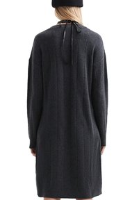 Übergroßes, dunkelgraues Strickkleid mit Rippenstruktur, langen Ärmeln und einer Schnürung auf der Rückseite.