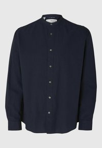 Chemise en lin navy avec col mao, manches longues et fermeture à boutons sur le devant. Elle présente une texture lisse et un ourlet arrondi.