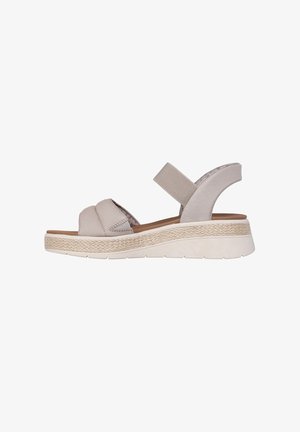 Sandali wedge beige con cinturini elastici, una suola intermedia in espadrille testurizzata e una suola in gomma liscia. La vista laterale evidenzia il design aperto sul retro.