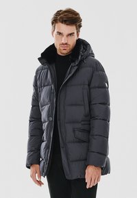 Wzmocniona, ciemnoszara kurtka z futrzanym kapturem, przednimi guzikami i bocznymi kieszeniami. Posiada pikowaną fakturę i regulowany ściągacz.