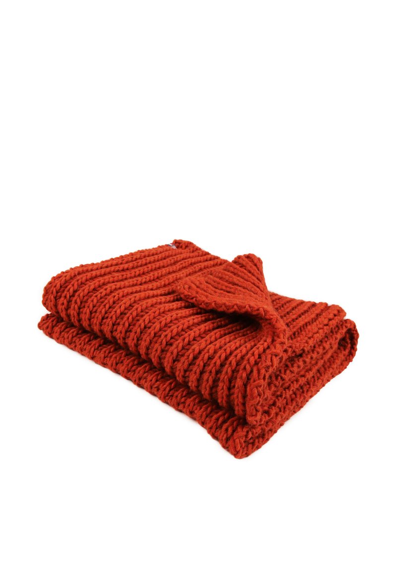 Couverture tricotée en rouge vif avec des côtes texturées et un coin replié, mettant en valeur une construction en laine épaisse.