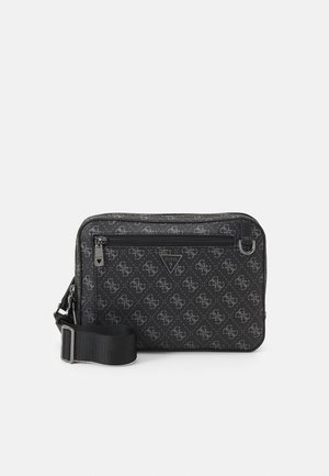 Bolsa negra con cremallera que presenta un patrón de logotipo texturizado, correa de nylon ajustable y herrajes de tono plateado. Diseño compacto y rectangular.