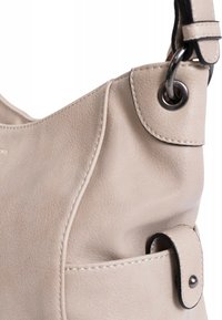 Borsa a mano in pelle beige con una texture morbida, design curvo e accessori in metallo nero, dotata di una tasca laterale e dettagli cuciti.