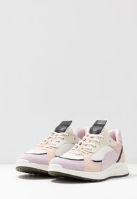 Sneakers con un design in materiali misti, caratterizzati da suede rosa chiaro, rete e dettagli bianchi. Tab dell'incolla nera e dettagli della suola testurizzata.