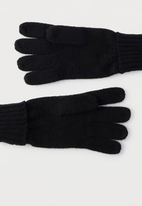 Para czarnych dzianych rękawiczek z prążkowanymi mankietami, ułożonych płasko na białym tle, pokazujących przód i tył.