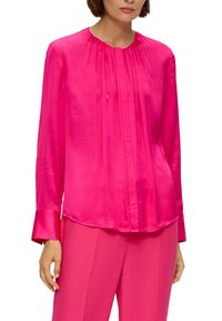 Fuchsia Seidenbluse mit langen Ärmeln, gefaltetem Vorderteil, rundem Ausschnitt und glatter Textur. Kombiniert mit passenden fuchsiafarbigen Hosen.