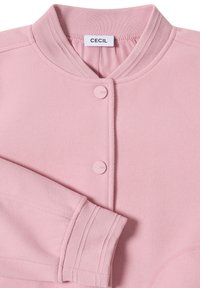 Różowa polarowa kurtka z okrągłym kołnierzem, z dwiema pasującymi guzikami i ściągaczami na rękawach. Miękka tekstura i minimalistyczny design.