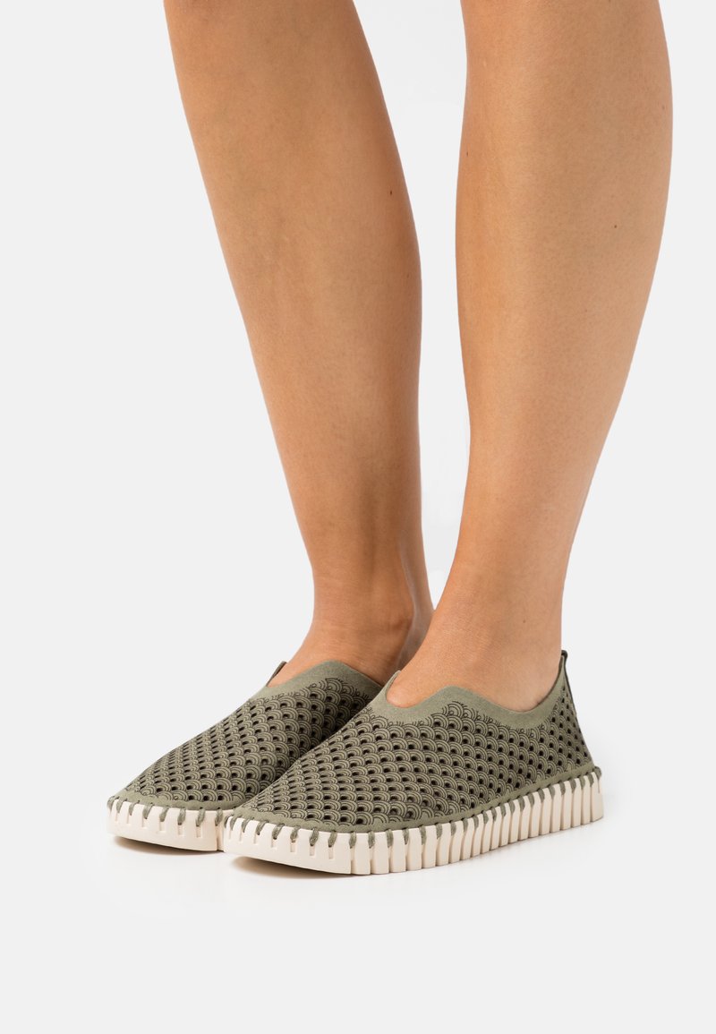 Olivengrønne slip-on sko med en tekstureret, åndbar overdel og hvid gummisål med en sålrand.