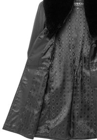 Czarna skórzana kurtka z puszystym futrzanym kołnierzem. Wnętrze ozdobione jest wzorzystą podszewką z okrągłymi wzorami. Widoczny zamek na guziki.