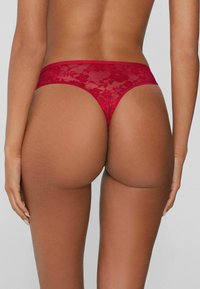 Roter Spitzen-String mit floralen Mustern, transparentem Stoff und schmalem Taillenbund, entworfen für minimalen Bedeckungsgrad.