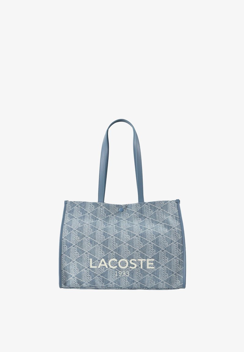 Borsa tote in denim blu con motivo a diamante, due spalline, chiusura con bottone e stampa "LACOSTE 1933" sul davanti.