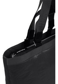 Borsa a spalla nera con una texture liscia e imbottita, due manici robusti e chiusura superiore con zip. L'interno presenta un'etichetta visibile.