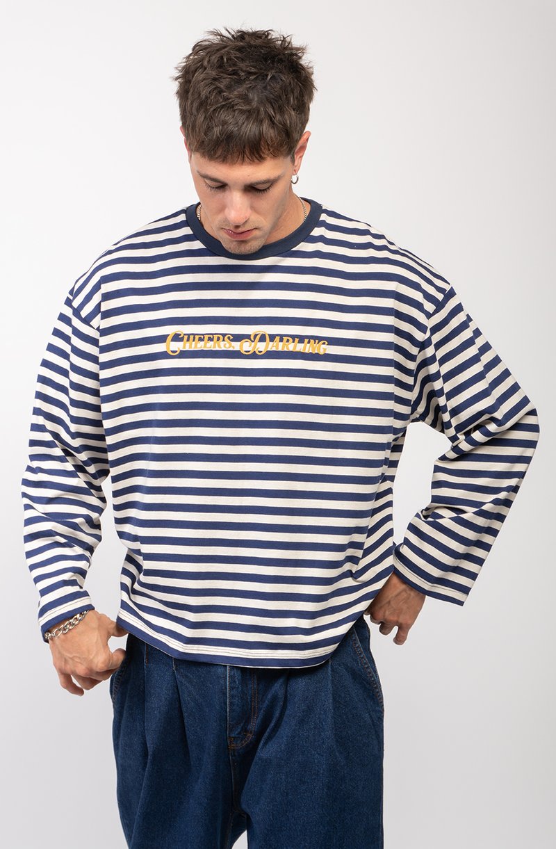 Pasiasta koszula z długim rękawem w kolorze granatowym i kremowym, z okrągłym dekoltem oraz nadrukiem na klatce piersiowej w kolorze żółtym z napisem "CHEERS, DARLING."