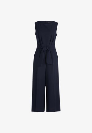 Mörkblå overall med ärmlös design, midja med bälte och vida byxor. Tillverkad av ett smidigt tyg med en subtil textur.