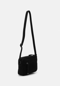 Czarna, teksturowana torba crossbody z długim paskiem, z zamykanym na zamek głównym przedziałem i dodatkową kieszenią z przodu.