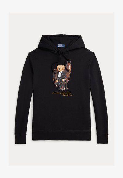 Juodas džemperis su minkšta medžiaga, kuriame ryškus grafinis vaizdas, pavaizduojantis lokį smokinge šalia arklių, su geltonu logotipu po juo.