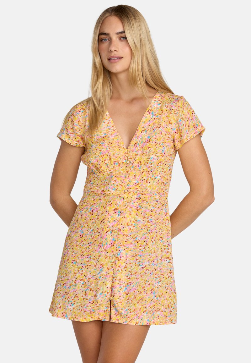 Robe courte jaune avec un col en V, des manches courtes et un motif floral avec des accents roses et bleus. Présente une taille cintrée et une jupe ample.
