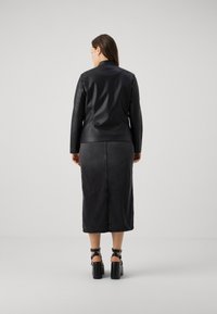 Black leather jacket with a fitted design, paired with a knee-length black skirt and chunky black platform heels. Smooth texture and minimal detailing.