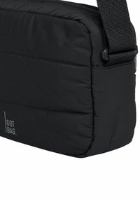 Borsa a messaggero nera, texture imbottita, forma rettangolare, con una tracolla regolabile e un dettaglio del logo in bianco sul fronte.