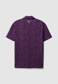 Camicetta viola in pizzo a maniche corte con motivo floreale, colletto e un fit rilassato caratterizzato da un intricato design testurizzato.