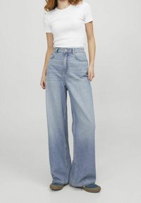 Ljusblå vida jeans i denim med hög midja, framfickor, dragkedja och subtil blekning.