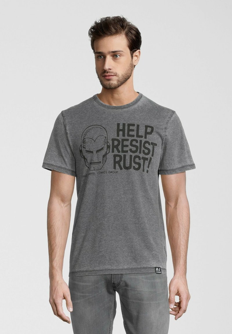 Grå bomulds T-shirt med et sort grafik af en hjelm og teksten "HJÆLP MED AT MODSTÅ RUST!" på forsiden. Rund hals og korte ærmer.