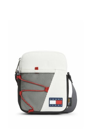 Kompakte weiße Crossbody-Tasche mit schwarzer Netz-Außentasche, roten Kordeln, grauem verstellbarem Gurt und Tommy Jeans Logo-Patch vorne.
