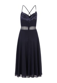 Tengerészkék ruha spagetti pántokkal, selyem bodorral, csipkés derékpánttal és lebegő szoknyával, térd hosszúságú szegéllyel és könnyű anyaggal.