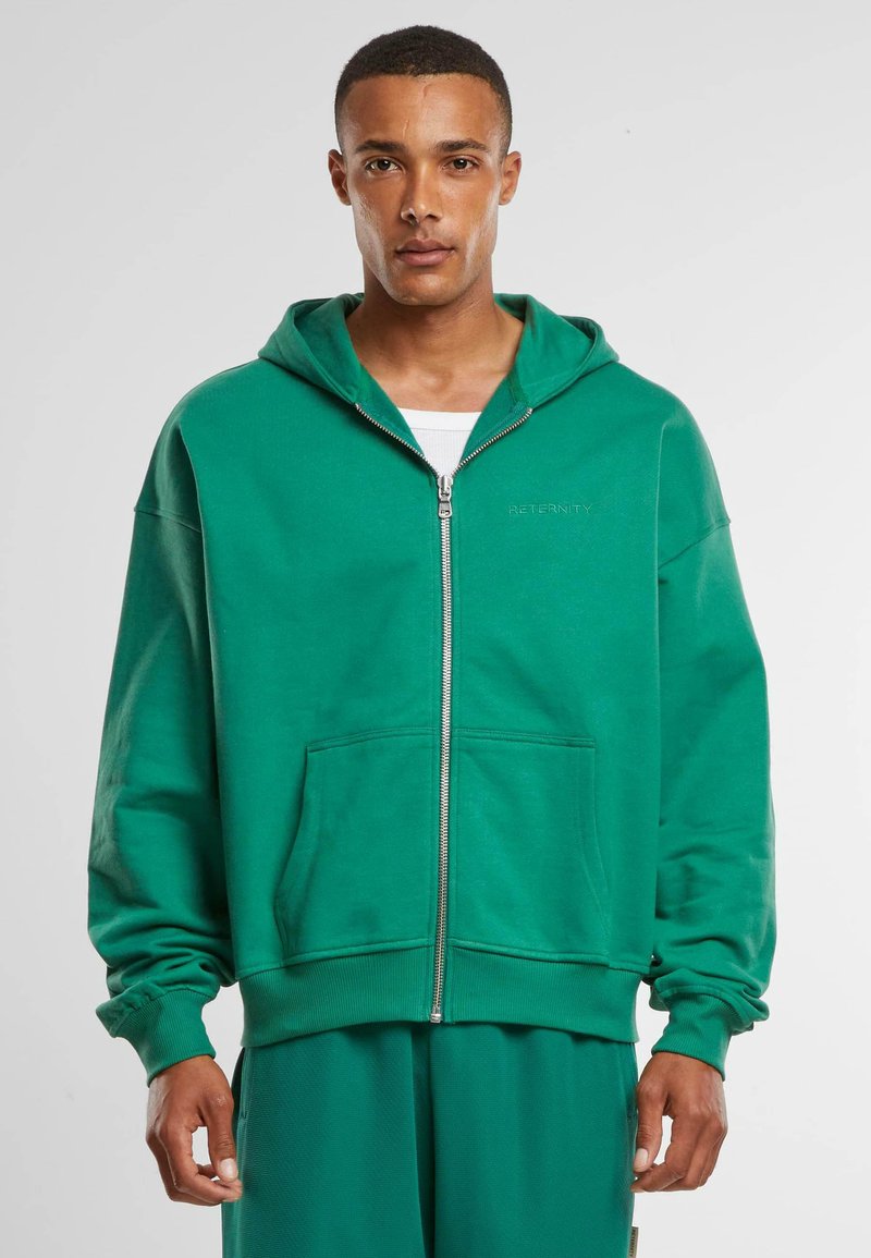 Hoodie zippé vert en coton, avec une poche avant, des poignets côtelés et une coupe décontractée. Logo brodé sur la poitrine gauche.