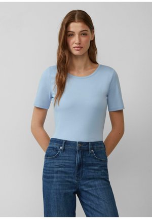 Lichtblauw T-shirt met korte mouwen gemaakt van zachte stof, met een ronde halslijn en een aansluitend ontwerp, gecombineerd met donkerblauwe denim jeans.