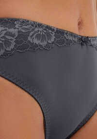 Boxer grigio in bikini con bordo in pizzo floreale in vita, caratterizzato da una superficie liscia e cuciture a contrasto lungo i bordi.