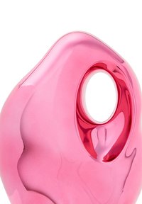 Przezroczysty różowy plastikowy obiekt o gładkim, organicznym kształcie i okrągłym otworze. Powierzchnia wydaje się błyszcząca, z delikatnymi krzywiznami i odbiciami.