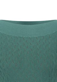 Suéter de punto con un patrón de olas en tejido de punto texturizado. El color es azul verdoso, con un amplio escote acanalado y detalles de puntadas abiertas.