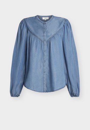 Lyseblå denimbluse med lange, puffede ærmer, rund hals, sammensyet skulderstykke og knaplukning foran.