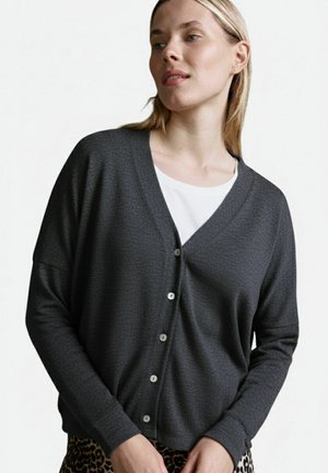 Grey knit cardigan with a V-neck and button closure, featuring long sleeves and a textured pattern. Paired with a white top.