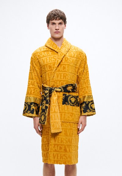 Gelber Bademantel aus Frottee mit wiederholtem "VERSACE"-Muster, schwarzen Akzenten, aufwendigen goldenen Verzierungen und passendem Gürtel.