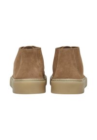 Stivaletti alla caviglia in suede marrone con una texture liscia, bordi arrotondati e una leggera suola in gomma, caratterizzati da cuciture minime lungo le cuciture.
