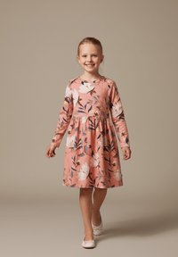 Różowa sukienka z długim rękawem w kwiatowy print w białe i niebieskie kolory, z zebranym w talii krojem, do kolan i okrągłym dekoltem. Nosi się z białymi baletkami.