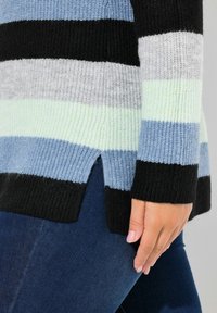 Gestrickter Pullover mit horizontalen Streifen in Schwarz, Grau, Hellblau und Mintgrün; gerippte Bündchen und seitliche Schlitze, weiche Textur.