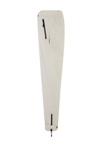 Pantaloni leggeri beige con vita elastica, tasche laterali con zip nere e polsini regolabili alle caviglie con toggles. Texture morbida.