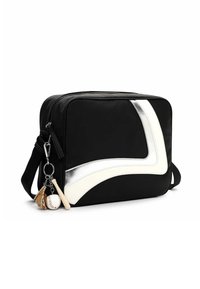 Sort nylon crossbody taske med hvide og sølvfarvede buede accenter. Har en nøglering med en baseball, handske og bat. Lynlås lukning.